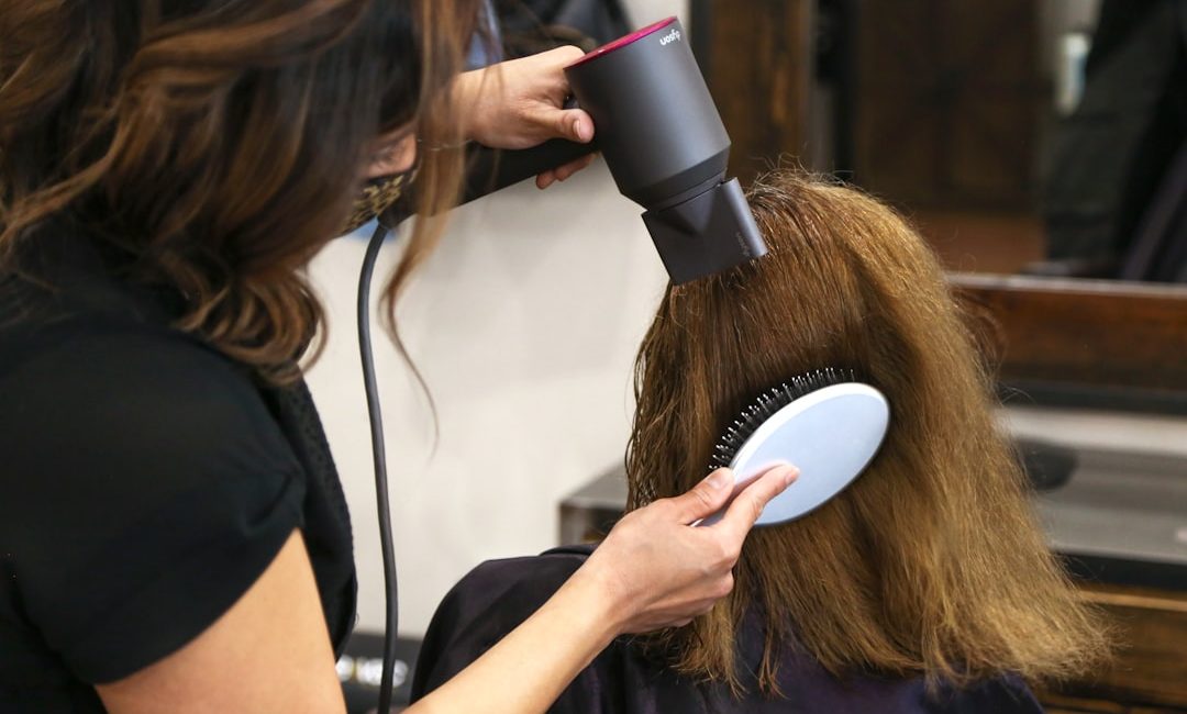 woman holding white and black hair blower