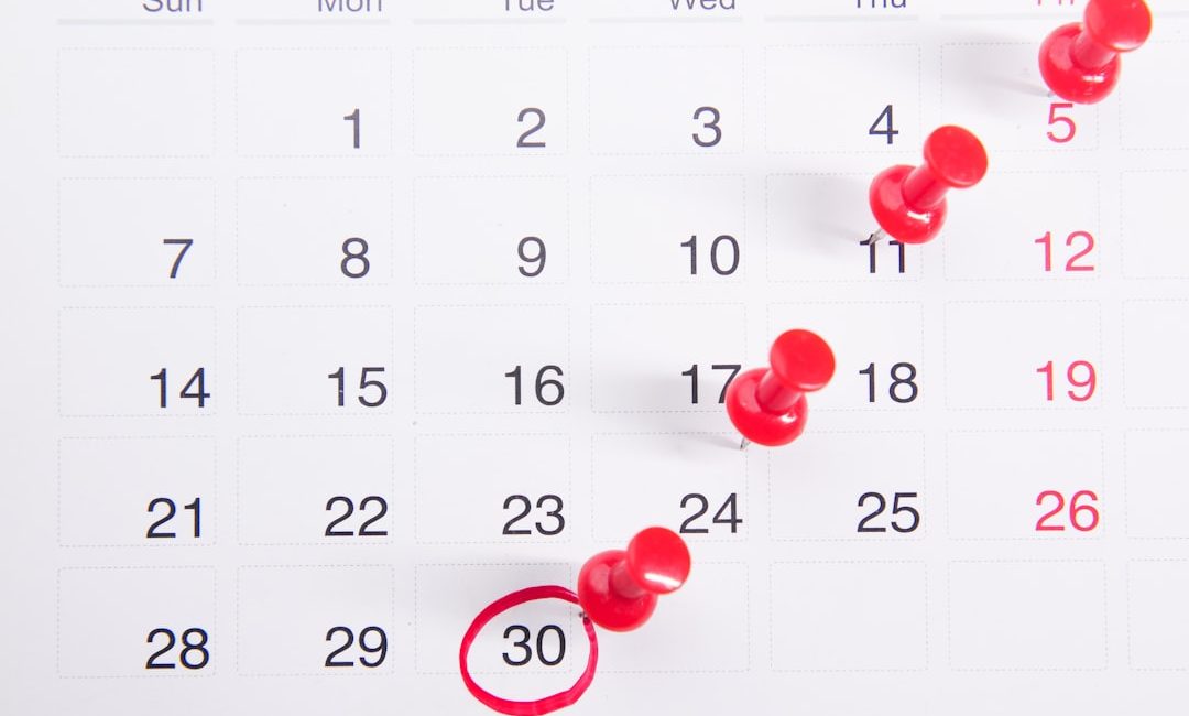 a calendar with red push buttons pinned to it
